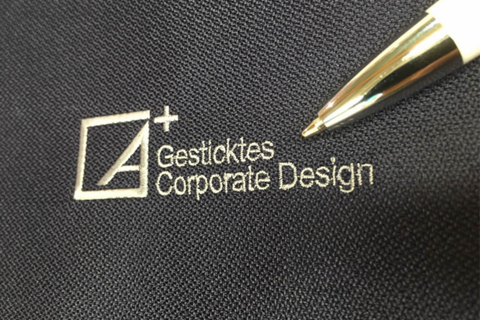 Nahaufnahme einer Logo-Bestickung mit goldfarbenem Garn